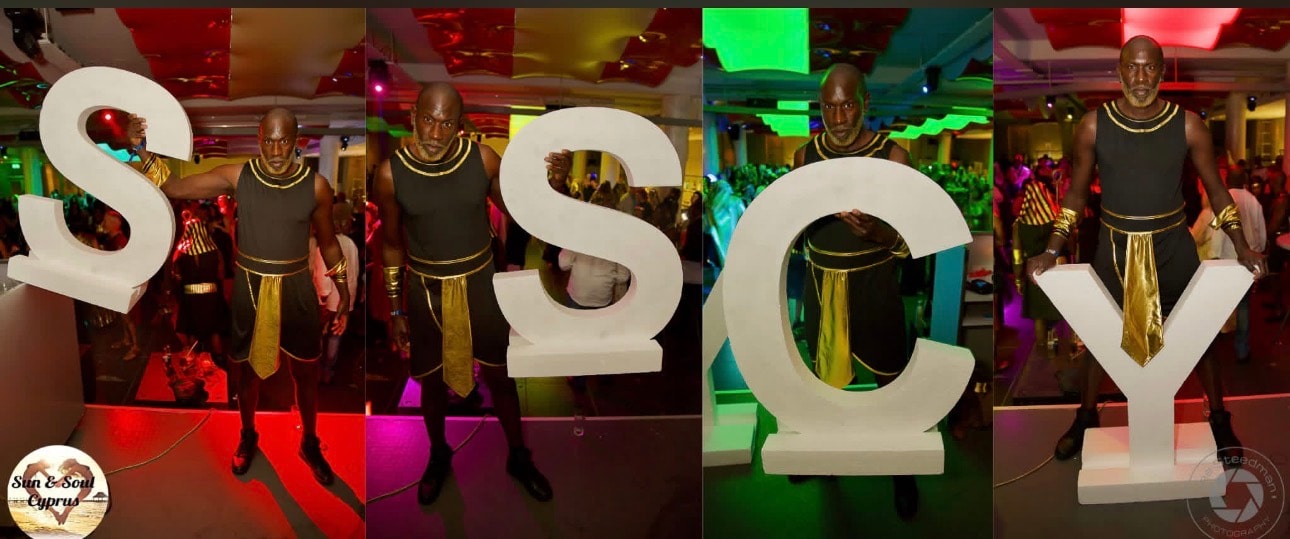 Performer posing with giant SSCY letters at Sun & Soul Cyprus